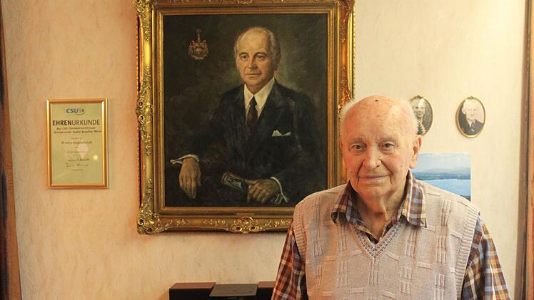 Baptist Hempfling vor seinem Porträt, das er bekannte Kunstmaler Heiner Grimm in Öl gemalt hat. Rechts die Eltern Hempflings, links die Ehrenurkunde der CSU für 65 Jahre Mitgliedschaft.  Foto: Schedel