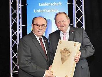 Symbolische Übergabe des goldenen Buches der Handwerkskammer für Unterfranken: Walter Heußlein (rechts) übernimmt das Amt des Präsidenten der Handwerkskammer für Unterfranken von Hugo Neugebauer.  Foto: Rudi Merkl