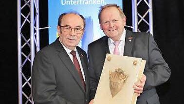 Symbolische Übergabe des goldenen Buches der Handwerkskammer für Unterfranken: Walter Heußlein (rechts) übernimmt das Amt des Präsidenten der Handwerkskammer für Unterfranken von Hugo Neugebauer.  Foto: Rudi Merkl