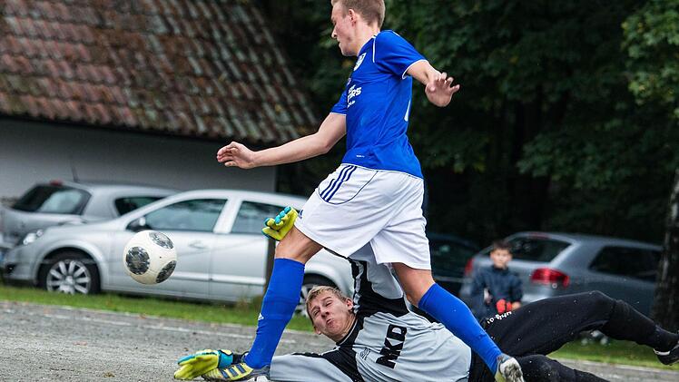 Bindlachs Torwart Sascha Meisel bringt den Metzdorfer Kevin Ramming zu Fall.