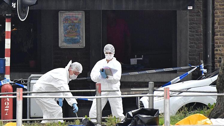 Polizisten untersuchen den Tatort, an dem zuvor Schüsse gefallen sind. Ein mutmaßlicher Terrorist hat nach offiziellen Angaben im belgischen Lüttich zwei Polizisten und einen Mann in einem Auto erschossen, bevor er selbst von Sicherheitskräften getötet wurde. Foto: Geert Vanden Wijngaert/AP/dpa