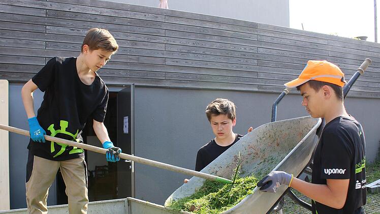 Konzentriert bei der Rasen-Arbeit (von links): Josef, Paul und Oliver von den Wonfurter "Mini-Firm-Workern".