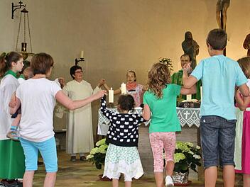Die Gemeindereferentin am Altar mit dem Familiengottesdienstteam. Foto: Werner Vogel