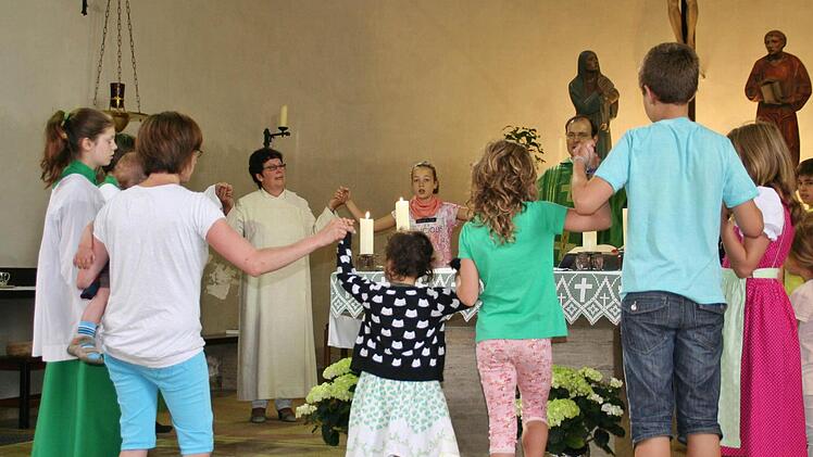 Die Gemeindereferentin am Altar mit dem Familiengottesdienstteam. Foto: Werner Vogel