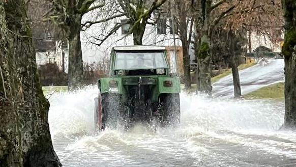 Die Straße nach Ebersbach ist überschwemmt - für den Traktorfahrer aber kein Problem. Foto: Jürgen Gärtner