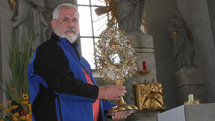 Vor den Flammen gerettet: Mesner Jürgen Müller zeigt die Monstranz, Sie wird bei Prozessionen umhergetragen. Das Kunstwerk gilt als das älteste in St. Bartholomäus und ist um 1720 entstanden. Foto: Ulrike Müller