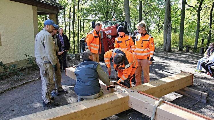 Kurz bevor das Kreuz in die Höhe gehievt wird, legen Mitarbeiter des Bauhofes letzte Hand an.