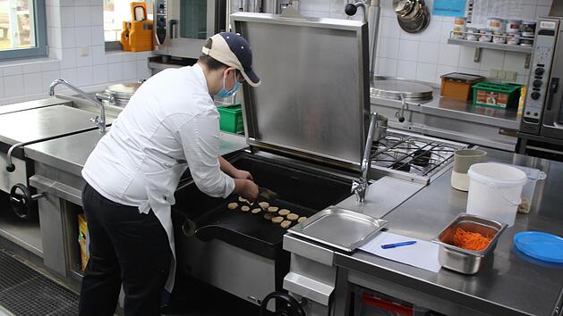 Azubi Robin Leibold steht alleine in der Küche und kocht für die sechs Gäste des Haus Volkersberg. Foto: Ellen Mützel