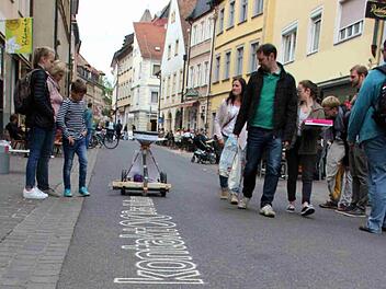 Was ist das denn? Der Sandschreiber zieht Blicke der Passanten in der Austraße auf sich und wirbt für "kontakt - Das Kulturfestival".  Foto: Sebastian Martin