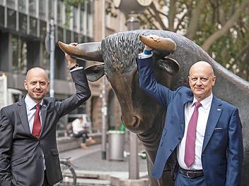 Christian Bruch (links), der Vorstandsvorsitzende von Siemens Energy, und Ralf Thomas, Finanzvorstand, mit der Skulptur des Bullen vor der Frankfurter Wertpapierbörse. Foto: Frank Rumpenhorst, dpa