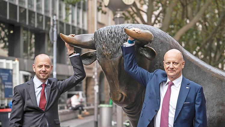 Christian Bruch (links), der Vorstandsvorsitzende von Siemens Energy, und Ralf Thomas, Finanzvorstand, mit der Skulptur des Bullen vor der Frankfurter Wertpapierbörse. Foto: Frank Rumpenhorst, dpa