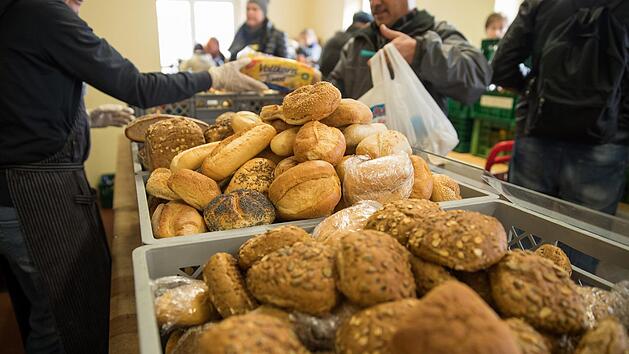 Ehrenamtliche Mitarbeiter der N&uuml;rnberger Tafel verteilen an Nutzer der Einrichtung. Immer mehr Rentner stehen bei den Tafeln f&uuml;r kostenlose Lebensmittel an.  Foto: Daniel Karmann/dpa