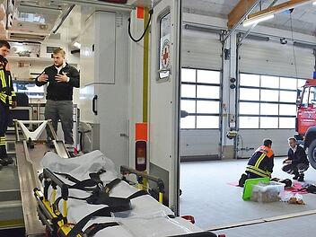 Im Rettungswagen erläuterte Florian Barthelmes den Medumat und wie man ihn schnell von der Wandsicherung lösen kann, während es draußen um Wiederbelebungsmaßnahmen ging. Hier war Max Rockenzahn der Ausbilder.  Fotos: Hanns Friedrich