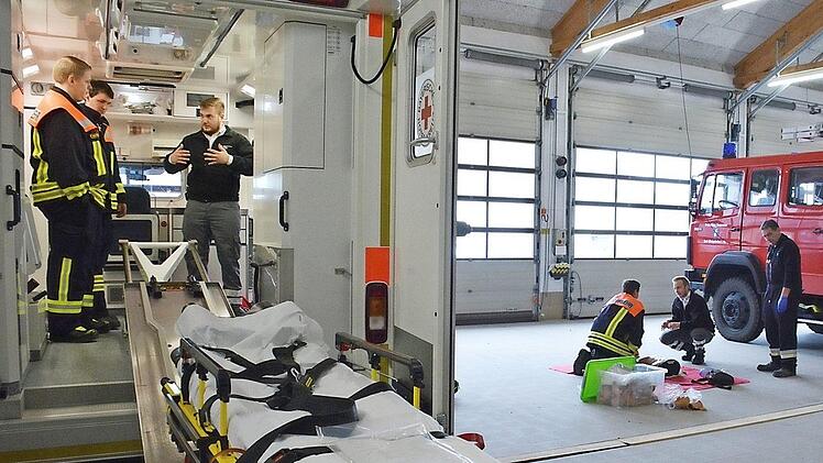 Im Rettungswagen erläuterte Florian Barthelmes den Medumat und wie man ihn schnell von der Wandsicherung lösen kann, während es draußen um Wiederbelebungsmaßnahmen ging. Hier war Max Rockenzahn der Ausbilder.  Fotos: Hanns Friedrich