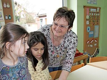 Kindern aus der "Waldgruppe" zeigt Roswitha Finsel Fotos aus den Anfängen ihrer Kinderpflegerinnenzeit. Da mussten die Mädchen schon genau hinschauen, um Roswitha Finsel zu entdecken.  Foto: Alexandra Kemnitzer