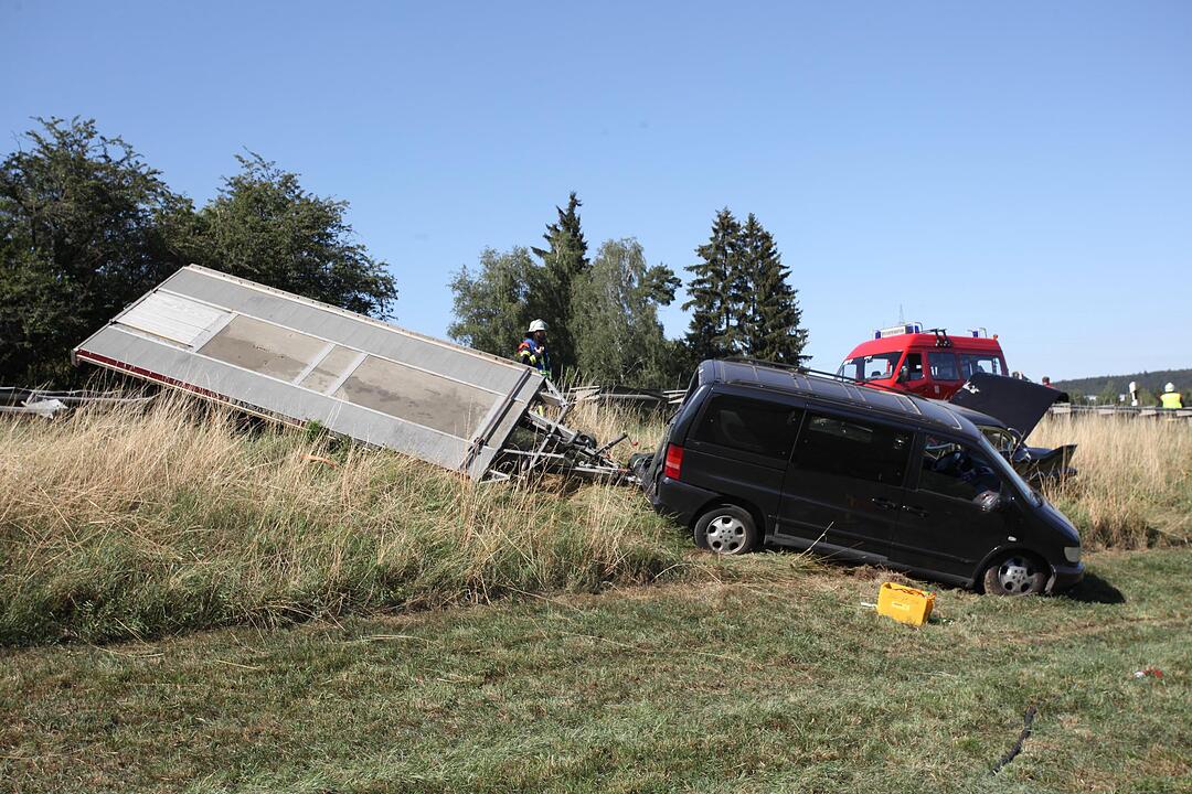 Mit Cadillac beladener Auto-Anhaenger kommt von der Fahrbahn ab