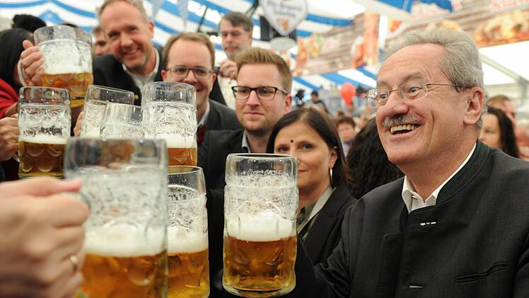 Der Münchner Oberbürgermeister, Christian Ude (SPD), prostet am 02.09.2013 in Abensberg (Bayern) beim politischen Gillamoos-Frühschoppen seinen Tischnachbarn mit seinem Bierkrug zu. Das Gillamoos ist eines der größten und ältesten Volksfeste Niederbayerns und bietet traditionell einen politischen Schlagabtausch der Parteien. Foto: Tobias Hase/dpa
