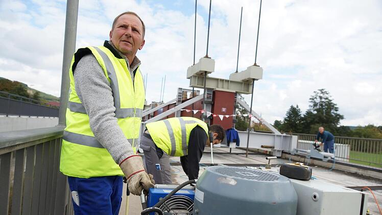Helmut Dahler regelt die Hydraulikanlage, die den Träger über die Brücke drückt. Foto: Arkadius Guzy