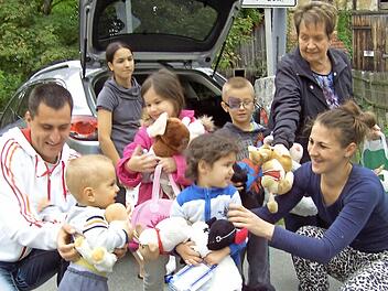 Ansteckende Freude: Lilo Grunow (hinten rechts) verteilt Geschenke an eine Flüchtlingsfamilie.  Foto: Gerhard Schmidt