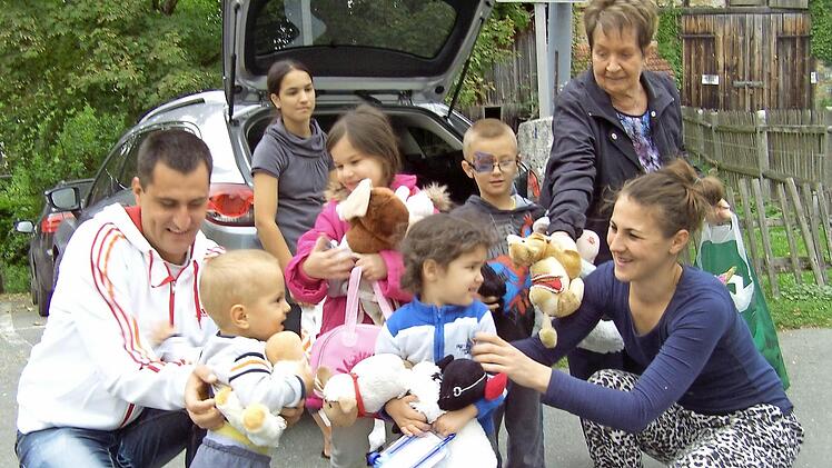 Ansteckende Freude: Lilo Grunow (hinten rechts) verteilt Geschenke an eine Flüchtlingsfamilie.  Foto: Gerhard Schmidt
