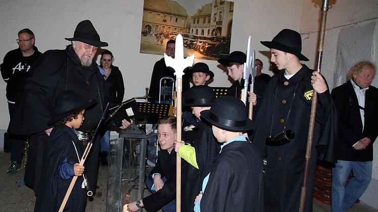 Mit dem Entzünden der großen Nachtwächterlaterne durch Bürgermeister Tobias Ehrlicher (Bildmitte) begann am Donnerstag die neue Nachtwächtersaison. Wegen des Dauerregens fand der Auftakt nicht am historischen Pulverturm, sondern in der Scheune des Café Faudler statt. Foto: Bettina Knauth