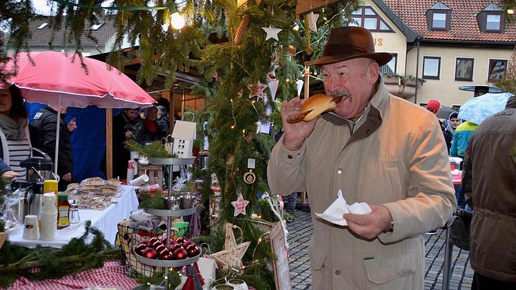Ein echter Genussmoment - Georg Wehner aus Wollbach beißt hier in eine Wildschweinbratwurst, die die Familie Strauch aus Lauter an ihrem Stand verkauft. Der Erlös geht an die Franz-von-Prümmer-Schule.Foto: Kathrin Kupka-Hahn