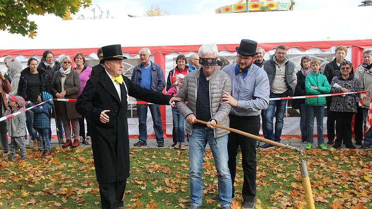 Der Hahnenschlag ist eine weitere Attraktion der Untersiemauer Kirchweih. Viele Besucher kommen auch aus dem Umland nach Untersiemau. Im Ring verbinden Edgar Rödel und Tobias Baum die Augen des "Delinquenten" und drehen ihn um seine eigene Achse. Foto: Michael Stelzner