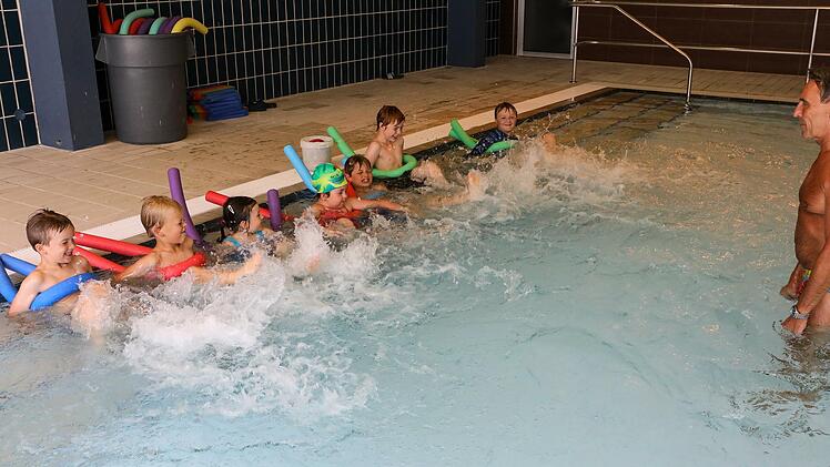 Einmal strampeln fürs Foto, bitte! Sieben Kinder können bei Joachim Schumann (rechts) einen Ferienschwimmkurs machen.