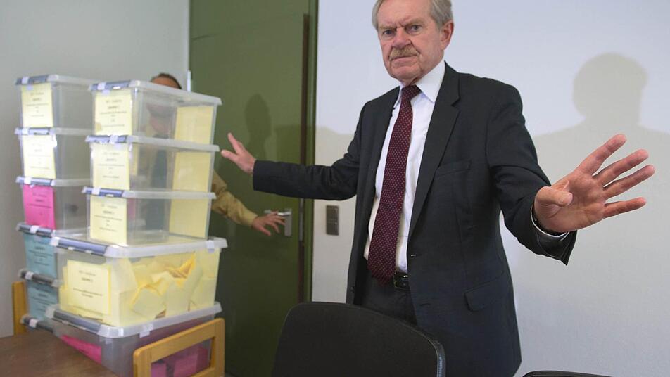 Der Präsident des Oberlandesgerichts, Karl Huber, steht am 29.04.2013 im Strafjustizzentrum in München nach der Pressekonferenz, auf der die Vergabe der Presseplätze im NSU-Prozess bekanntgegeben wurde, neben den durchsichtigen Plastikkästen, in denen die Loszettel in verschiedene Gruppen aufgeteilt wurden. Foto: Peter Kneffel/dpa
