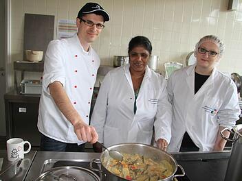 Monica Dippold (Mitte) ließ Peter Namislo und Madlen Sander in den Kochtopf schauen: Schon mittags kamen zur Eröffnung der interkulturellen Woche selbstgekochtes Gemüse und Hähnchen-Curry mit Kaha Buth (gelbem Reis) auf den Tisch. Fotos: Sonja Adam