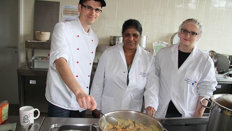 Monica Dippold (Mitte) ließ Peter Namislo und Madlen Sander in den Kochtopf schauen: Schon mittags kamen zur Eröffnung der interkulturellen Woche selbstgekochtes Gemüse und Hähnchen-Curry mit Kaha Buth (gelbem Reis) auf den Tisch. Fotos: Sonja Adam