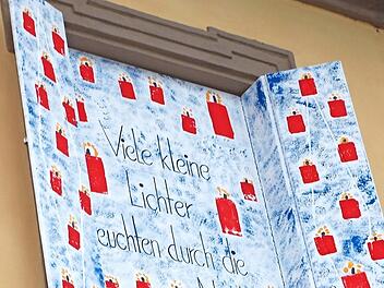 Nicole Hönninger vom Elternbeirat öffnete das dritte Adventsfenster, hinter dem entsprechend dem Motto viele kleine Lichter zum Vorschein kamen.  Fotos: Alfred Thieret
