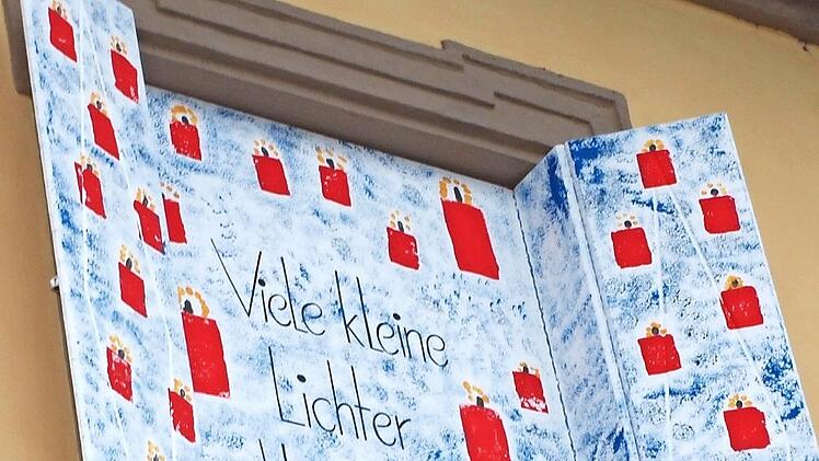 Nicole Hönninger vom Elternbeirat öffnete das dritte Adventsfenster, hinter dem entsprechend dem Motto viele kleine Lichter zum Vorschein kamen.  Fotos: Alfred Thieret