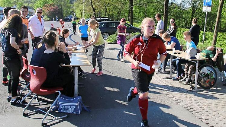 Über vier Stunden lang absolvieren alle Klassen reihum die rund 400 Meter lange Strecke zwischen Schulparkplatz und Stadtmauer im Seßlach. Für jede Runde, die die Jungen und Mädchen in 20 Minuten laufen, zahlen Sponsoren Geld für die Coburger Stiftung für krebskranke Kinder. Mitschüler dokumentieren jede Runde mit einem Stempel auf der Teilnehmerkarte. Foto: Bettina Knauth