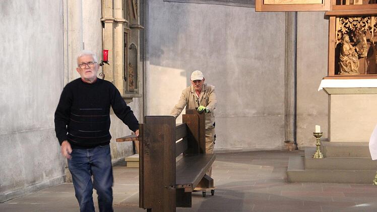 Helfer transportieren die Bänke aus dem Altarraum ab.Heike Beudert