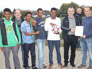 Die jungen Männer aus Äthiopien freuen sich riesig über den Spielball vom TSV Scherneck und die Verantwortlichen finden die Spende gut, um für die Gäste eine Fußballausrüstung anschaffen zu können (von links): Muhammad Tamaam, Vorsitzender Harald Schneider, Abdul Kadir Ahmed, Saad Quasüm, Muhammad Mahmud, Egon Grünbeck und Jugendleiter Michael Mnich. Foto: Michael Stelzner