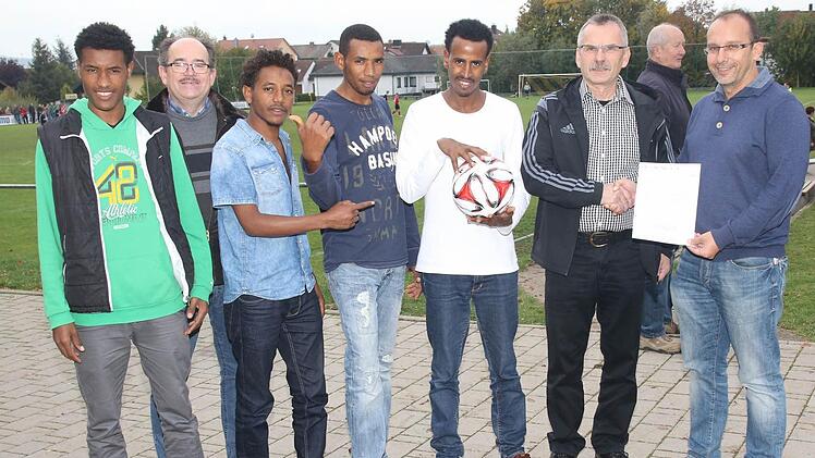 Die jungen Männer aus Äthiopien freuen sich riesig über den Spielball vom TSV Scherneck und die Verantwortlichen finden die Spende gut, um für die Gäste eine Fußballausrüstung anschaffen zu können (von links): Muhammad Tamaam, Vorsitzender Harald Schneider, Abdul Kadir Ahmed, Saad Quasüm, Muhammad Mahmud, Egon Grünbeck und Jugendleiter Michael Mnich. Foto: Michael Stelzner