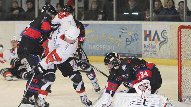 Turbulente Szene vor dem Dorfener Gehäuse: Haßfurts Martin Oertel, der von Dorfens Dominik Fuchs hart bedrängt wird, schafft es zwar, noch an den freiliegenden Puck zu kommen. Gästekeeper Andreas Tanzer aber kann ihn gerade noch vorbei lenken. Links im Hintergrund Haßfurts Eugen Nold, verdecket der Dorfener Thomas Vogl.