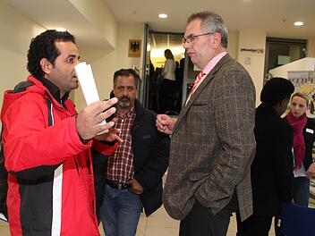 Am Stand des Verkehrsinstitutes betätigt sich Ali Alfarej als Dolmetscher. Viele Flüchtlinge hatten in ihrem Heimatland den Lkw-Führerschein, doch der syrische Führerschein wird in Deutschland nicht anerkannt. Foto: Sonja Adam