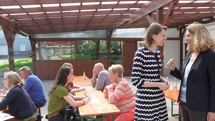 Emmi Zeulner (MdB, Zweite v. r.) im Gespräch mit Architektin Birgit Dietz unter der Pergola des Trieber Sportheims. An den Tischen Studentinnen bei der Befragungsrunde.