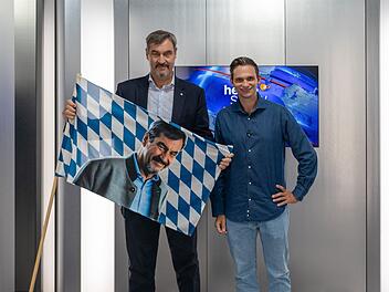 Ein Vier-Augen-Gespräch auf acht Quadratmetern in einem Fahrstuhl: Dem stellen sich Gastgeber Fabian Köster (rechts) und der bayerische Ministerpräsident Markus Söder.