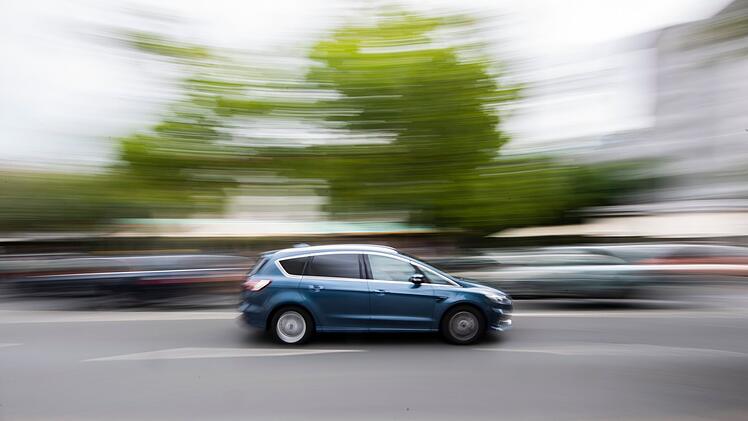 Auto f&auml;hrt innerorts &uuml;ber eine Stra&szlig;e