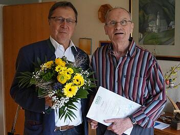 Pfarrer Roland Breitenbach (rechts) erhält von Bernd Eisenmann die Urkunde, die ihn zum Ehrenmitglied macht. Foto: DAV