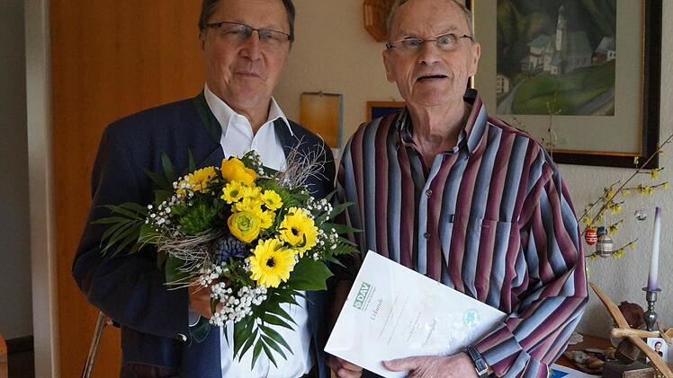 Pfarrer Roland Breitenbach (rechts) erhält von Bernd Eisenmann die Urkunde, die ihn zum Ehrenmitglied macht. Foto: DAV