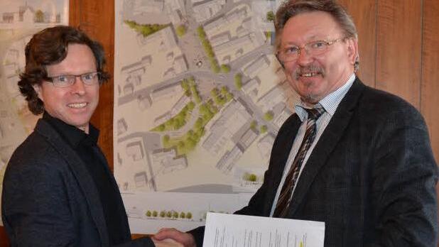 Bürgermeister Hans Pietz (rechts) gratulierte Tilman Latz zum ersten Preis beim Architektenwettbewerb "Neugestaltung Ortsmitte Rothenkirchen". Im Hintergrund rechts der Planentwurf. Foto: K.-H. Hofmann
