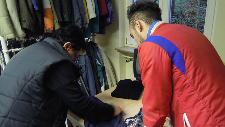 Helal Abdulghani beim Sortieren der Kleidung. Foto: Julia Raab