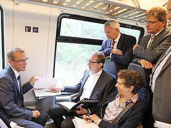 Die Bürgermeister aus dem südlichen Landkreis sowie der Bundestagsabgeordnete Thomas Silberhorn und Landrat Johann Kalb umringen im Regionalexpress nach Bamberg Bundesverkehrsminister Alexander Dobrindt und seine Mitarbeiterin Friederike Reineke. Foto: Barbara Herbst