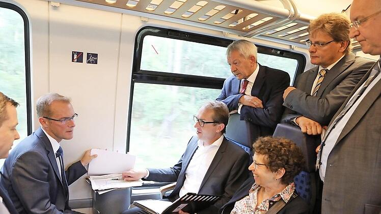 Die Bürgermeister aus dem südlichen Landkreis sowie der Bundestagsabgeordnete Thomas Silberhorn und Landrat Johann Kalb umringen im Regionalexpress nach Bamberg Bundesverkehrsminister Alexander Dobrindt und seine Mitarbeiterin Friederike Reineke. Foto: Barbara Herbst