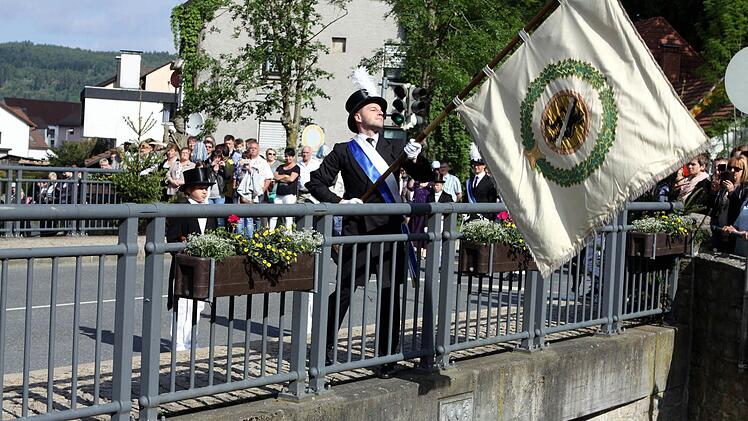 Der jüngste Stadtrat Sven Hofmann beim traditionellen Fahnenschwenken auf der Schwedenbrücke.  Foto: Michael Wunder