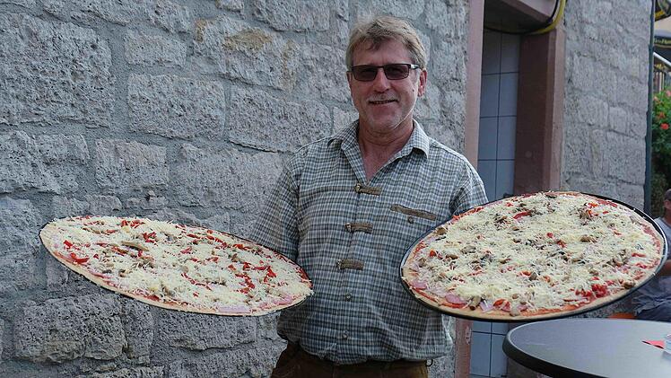 Helfer transportierten die Bleche mit den belegten Pizzen eine Etage tiefer zu den Öfen.Gerd Schaar